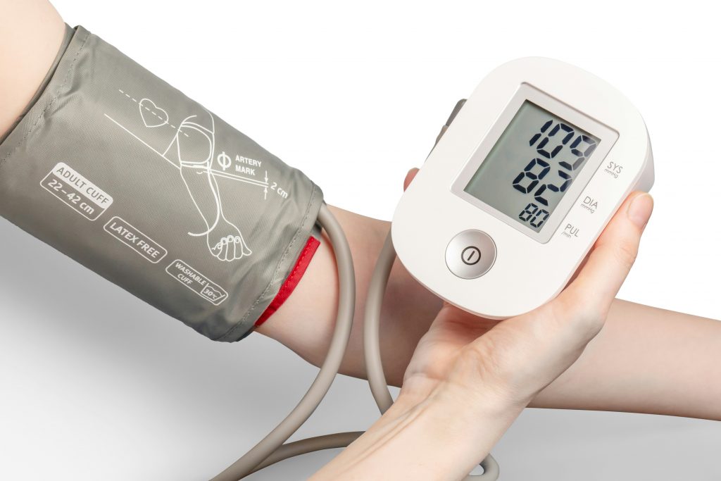 A digital blood pressure machine takes a read on a person's arm. Photo by Mockup Graphics on Unsplash.com